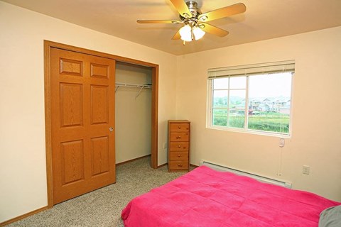 a bedroom with a bed and a ceiling fan