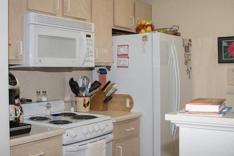 a small kitchen with a stove microwave and refrigerator