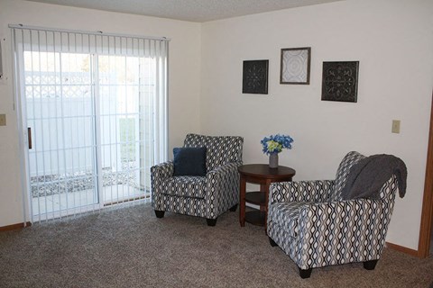 a living room with two chairs and a window
