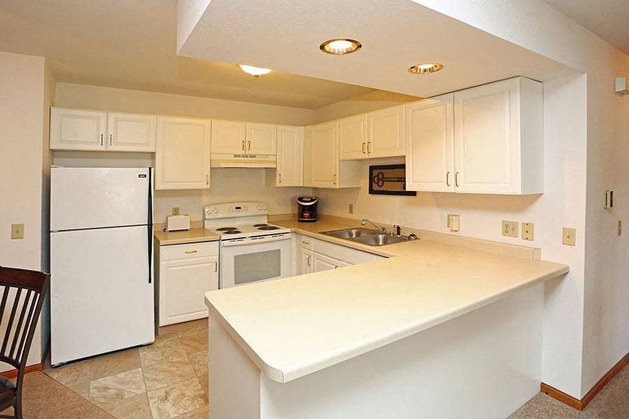 a kitchen with a white counter top and a refrigerator