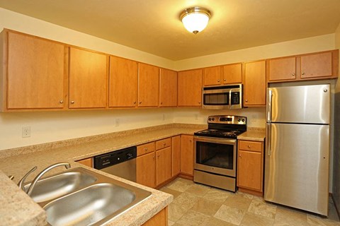 a kitchen with stainless steel appliances and wooden cabinets