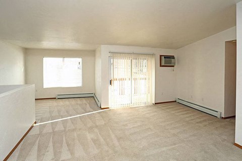 an empty living room with a door and a window