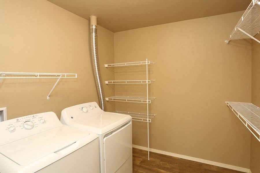 a bathroom with a washer and dryer and a closet with shelves