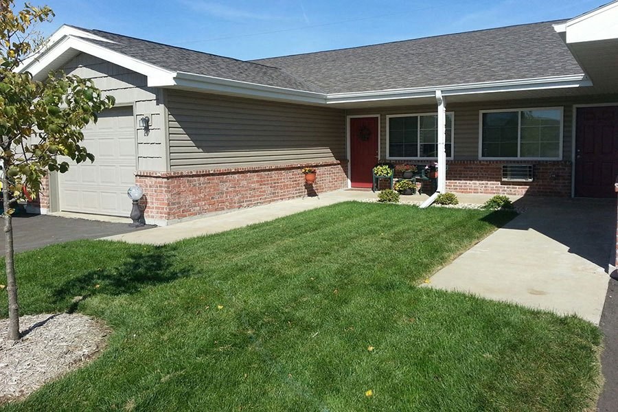 a house with a yard and a sidewalk in front of it