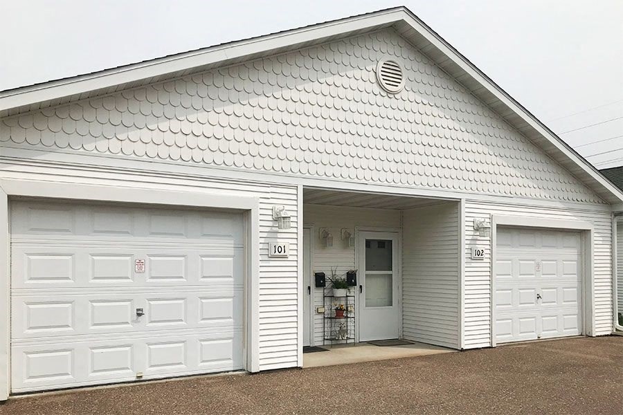 a white building with two white garage doors