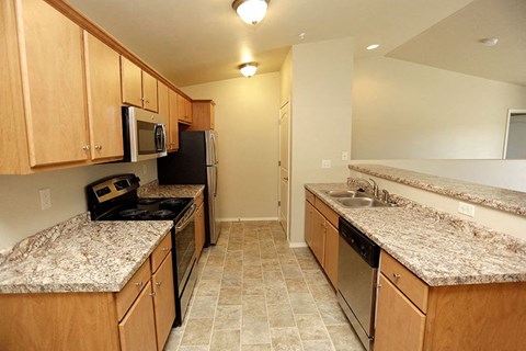 a kitchen with granite counter tops and stainless steel appliances