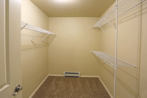 a walk in closet with two shelves and a heater