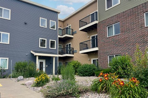 A building with a grey facade and a balcony with a black railing.