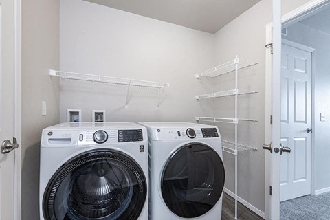 a laundry room with two washing machines and a closet
