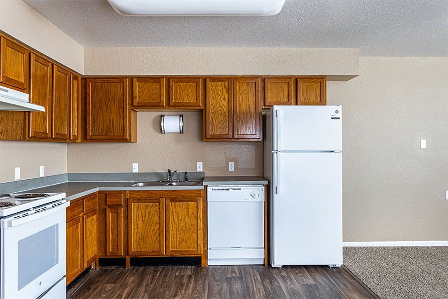 a kitchen with white appliances and wooden cabinets