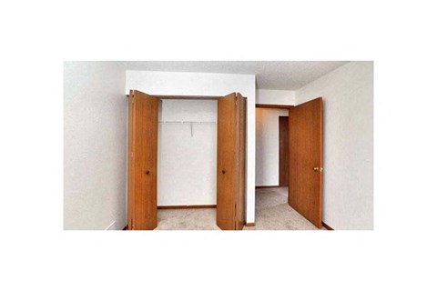 A room with a white wall and a brown door.