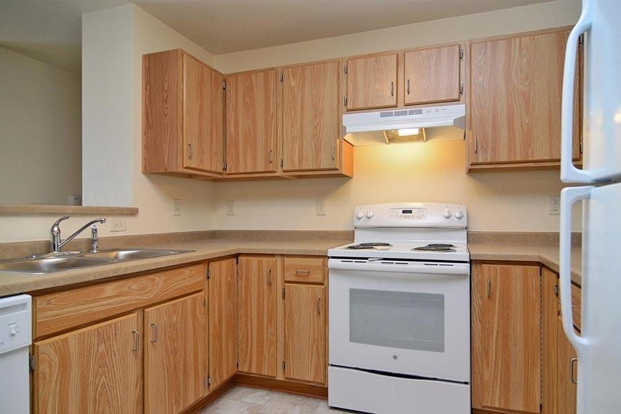 A kitchen with wooden cabinets and white appliances.