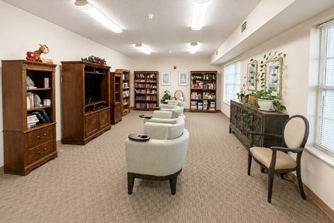 A room with a carpeted floor and a collection of bookcases filled with books.