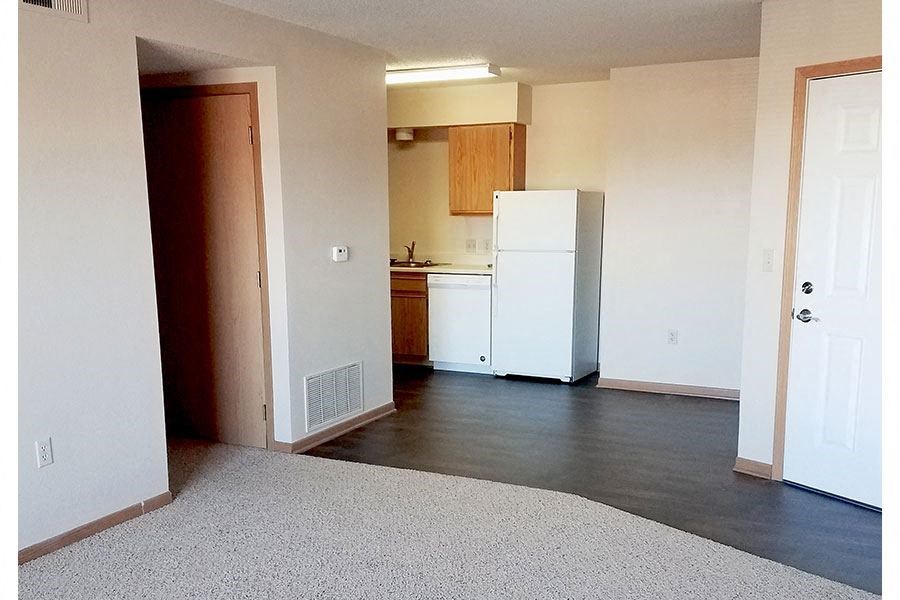 A kitchen with white appliances and wooden cabinets.