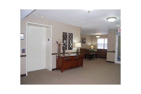 A room with a white door, a brown table, and a framed picture on the wall.