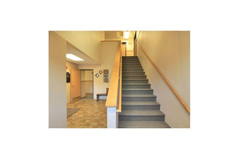 A hallway with a staircase leading to the second floor.