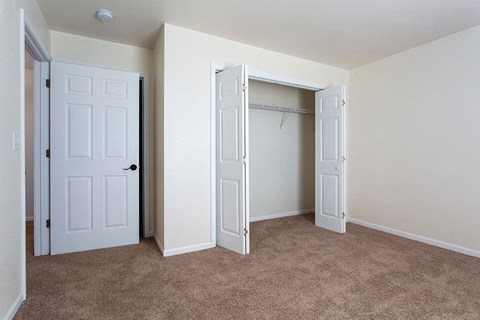 A room with a white door and a carpeted floor.
