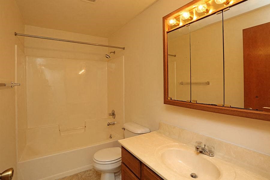 A bathroom with a toilet, sink, and shower.