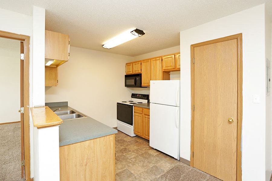 a kitchen with a white refrigerator and a sink