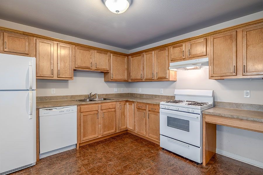 A kitchen with wooden cabinets and a white refrigerator.