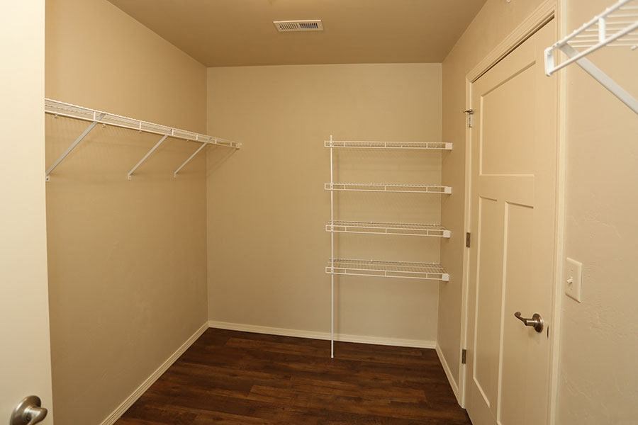 a room with a closet with shelves and a door
