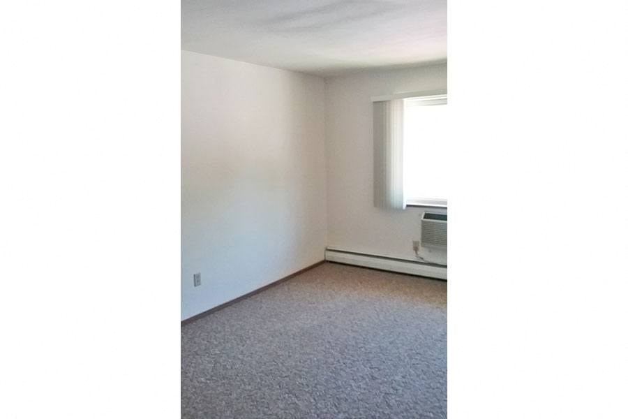 an empty room with a window and a carpet