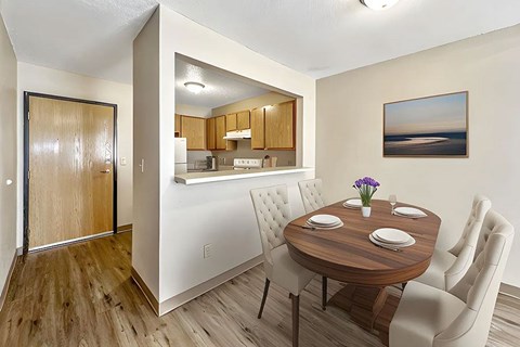 A dining room with a wooden table and chairs.