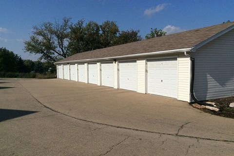 a row of white garage doors on the side of a building