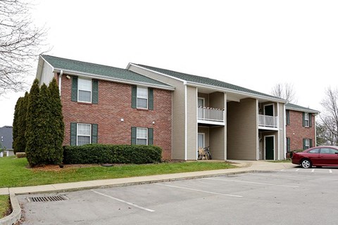 a red car parked in front of an apartment building