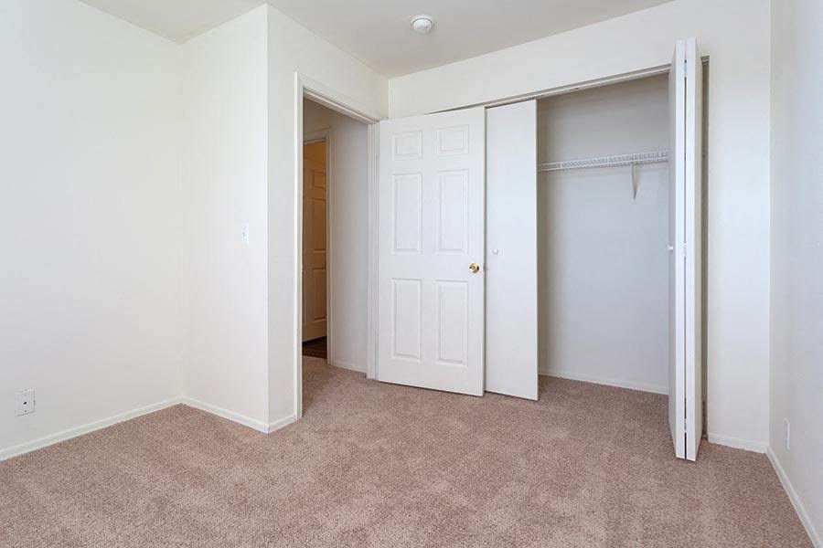 an empty bedroom with a closet and a door