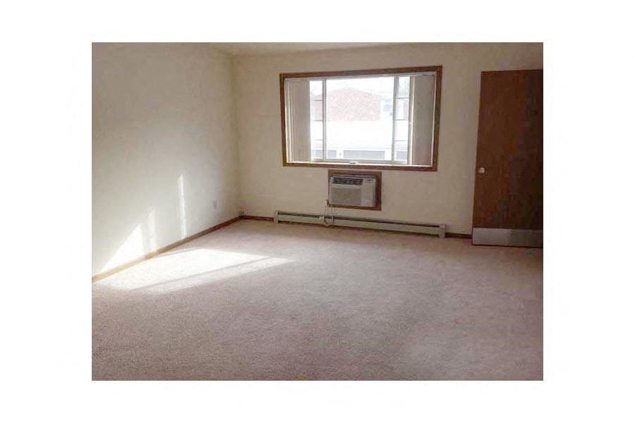 an empty room with a window and a radiator