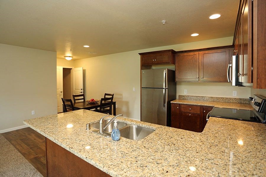 a kitchen with a granite counter top and a stainless steel refrigerator