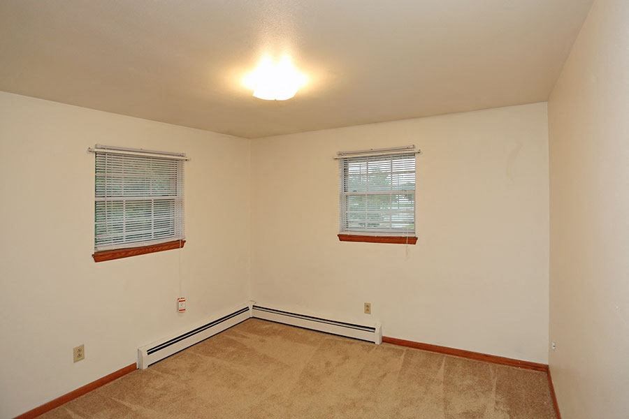 an empty room with two windows in it