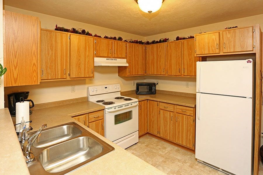 a kitchen with white appliances and wooden cabinets