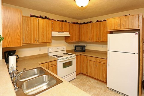 a kitchen with white appliances and wooden cabinets
