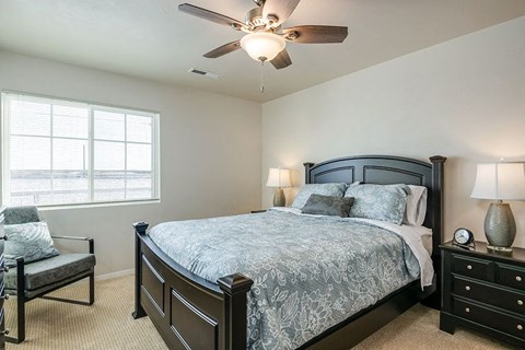 a bedroom with a bed and a ceiling fan
