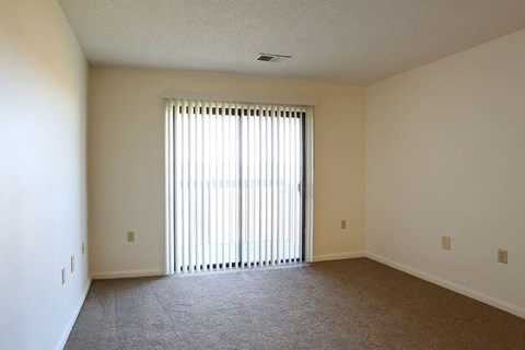an empty living room with a large window and