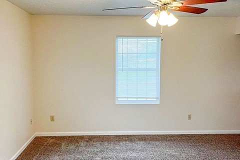 a empty room with a ceiling fan and a window