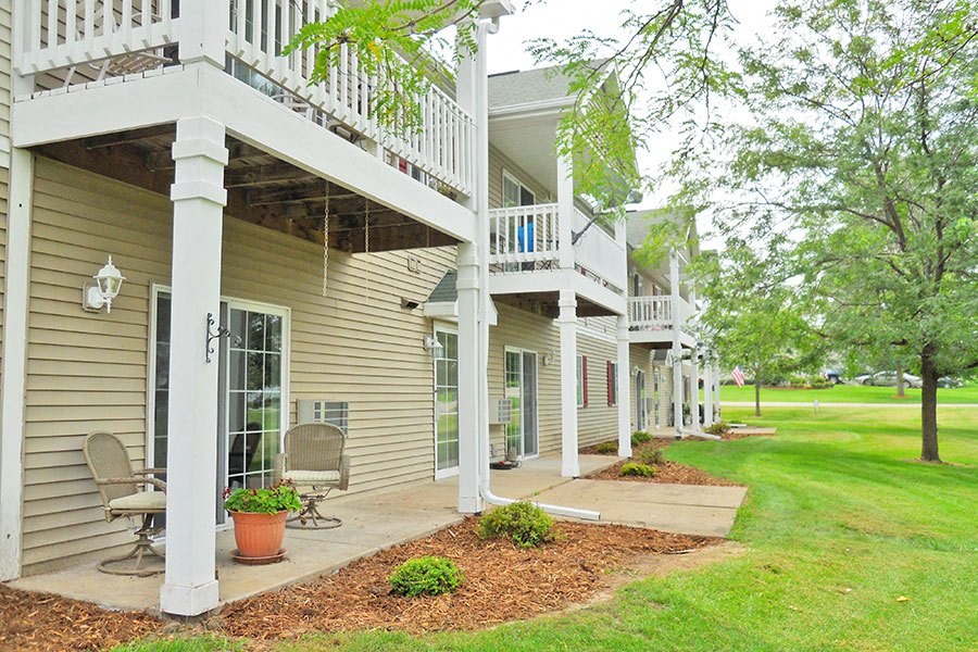 the front of a house with a porch and a lawn