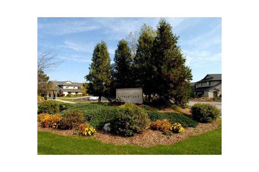 a sign is in the middle of a garden