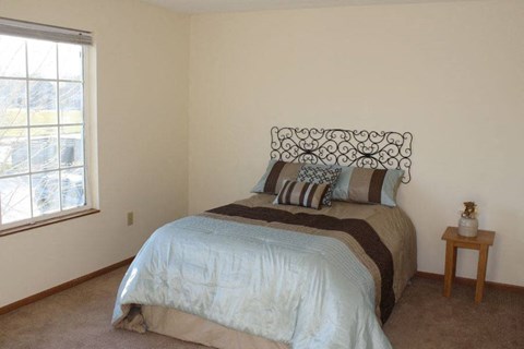 a bedroom with a bed and a window