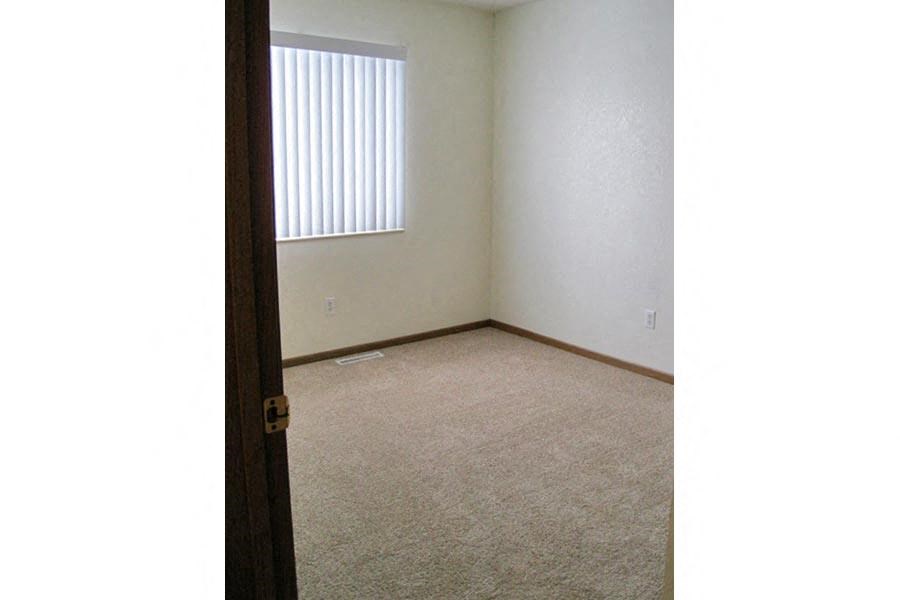 an empty room with a window and a door