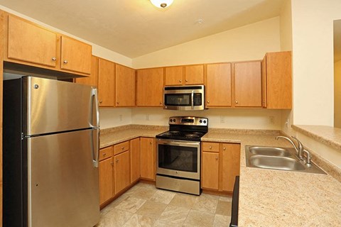 a kitchen with stainless steel appliances and wooden cabinets