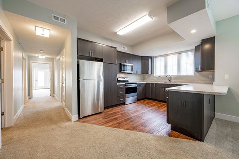 A kitchen with a refrigerator, oven, and microwave.