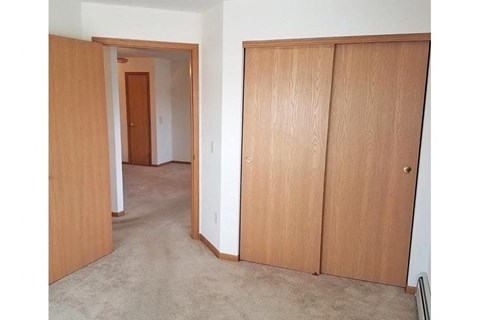 a bedroom with a closet and a door to a hallway