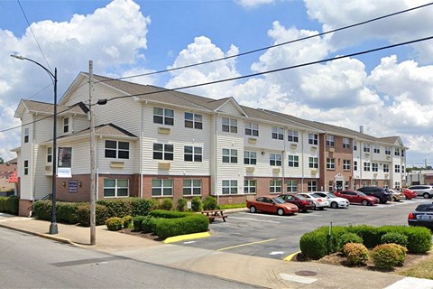 an apartment building with cars parked in a parking lot