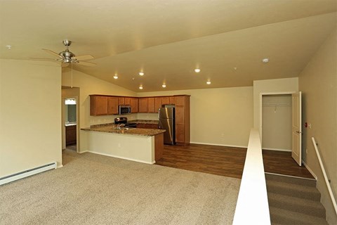 an empty living room with a kitchen and