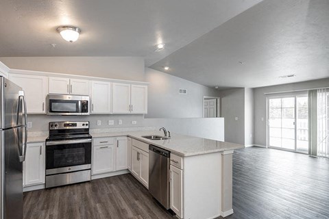 an empty kitchen with white cabinets and stainless steel appliances
