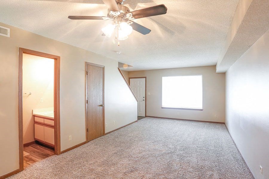 an empty room with a ceiling fan and a window