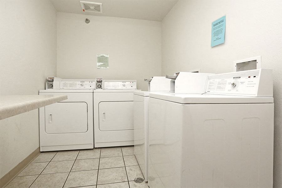 a group of washers and dryers in a laundry room